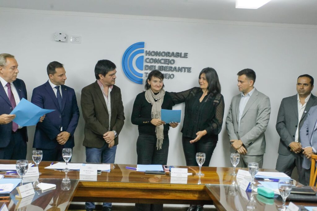 La organizadora de la Barrileteada, Fernanda Barnes, con una carpeta celeste, junto a la concejala Daniela Bravo en el Concejo Deliberante de Tafí Viejo.